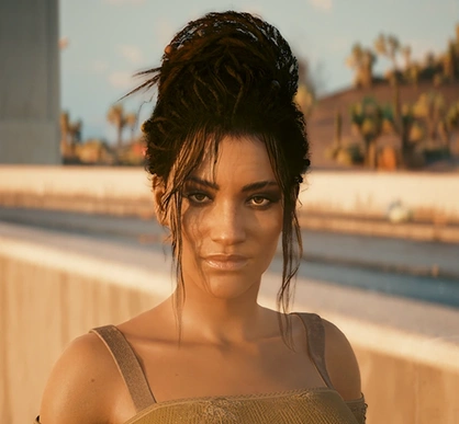 Vrouw met donker haar in een losse knot, gekleed in een off-shoulder kaki top met patches. Ze staat buiten, op de achtergrond is een wazig stadsgezicht te zien, wat een rustig gevoel geeft